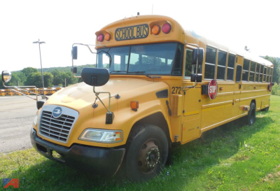 Yellow 2019 Blue Bird Vision school bus with stop sign, front grille, mirrors, and doors visible in a parking lot.