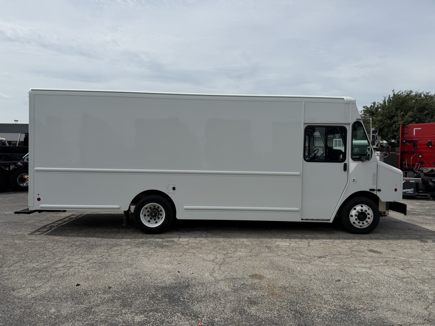 Harbinger S554 step van side view showing plain white cargo body and cab with black tires