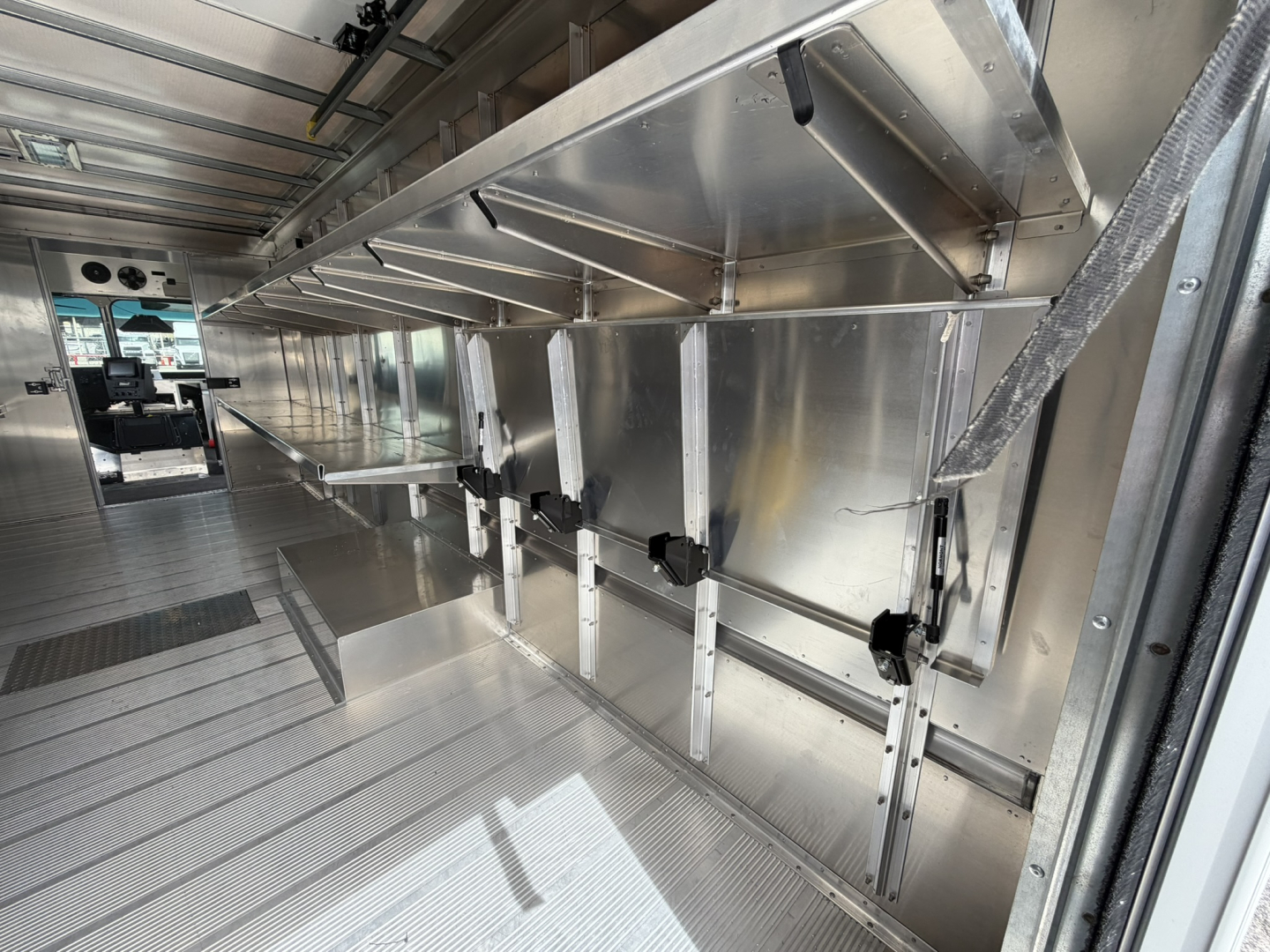 Harbinger S655 step van interior showing aluminum side rails and storage compartments with metal flooring and tracks.