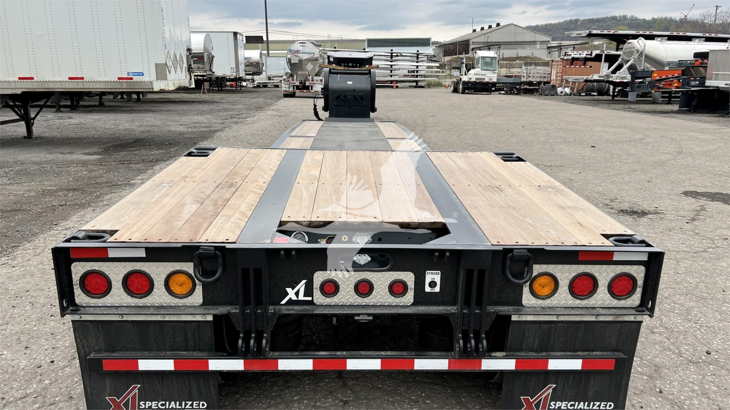 XL Specialized mini deck trailer rear view showing wooden deck planks, black frame, taillights, and reflective safety stripes