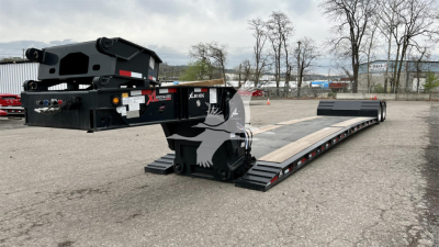 Lowboy trailer showing XL Specialized logo and extended ramp sections with model details and serial tag visible.