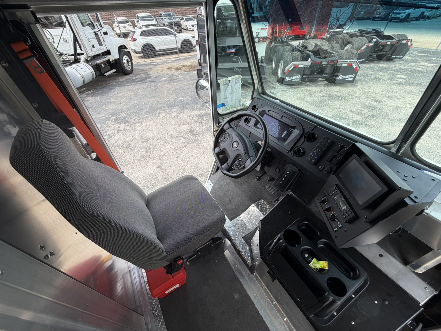 Harbinger S534 truck cab interior showing driver's seat, steering wheel, dashboard, and center console with cupholders.
