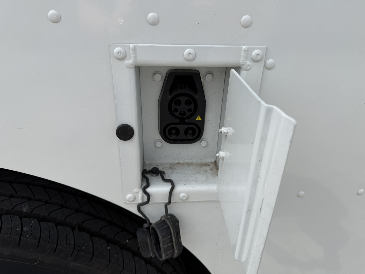 Harbinger S534 side view showing a dual-recessed electrical receptacle panel with two round sockets, open access door, and nearby pedal/step area.