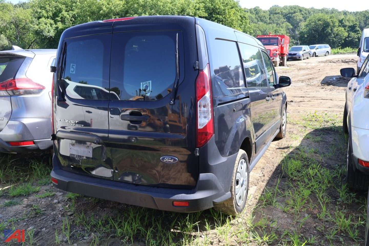 Ford Transit Connect cargo van rear view showing taillights and rear doors in a used vehicle lot.