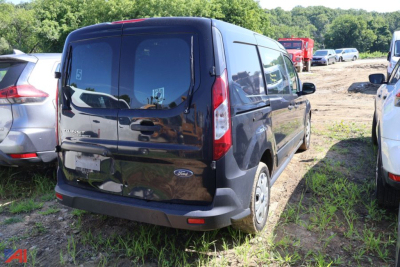 Ford Transit Connect cargo van rear view showing taillights and rear doors in a used vehicle lot.