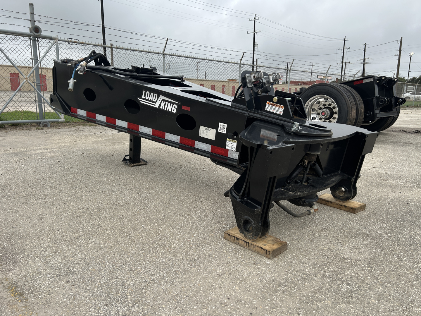 Load King trailer SB141/2-43 9' section showing black steel frame with red/white reflective safety bars and stabilizing jacks extended, Load King branding visible.