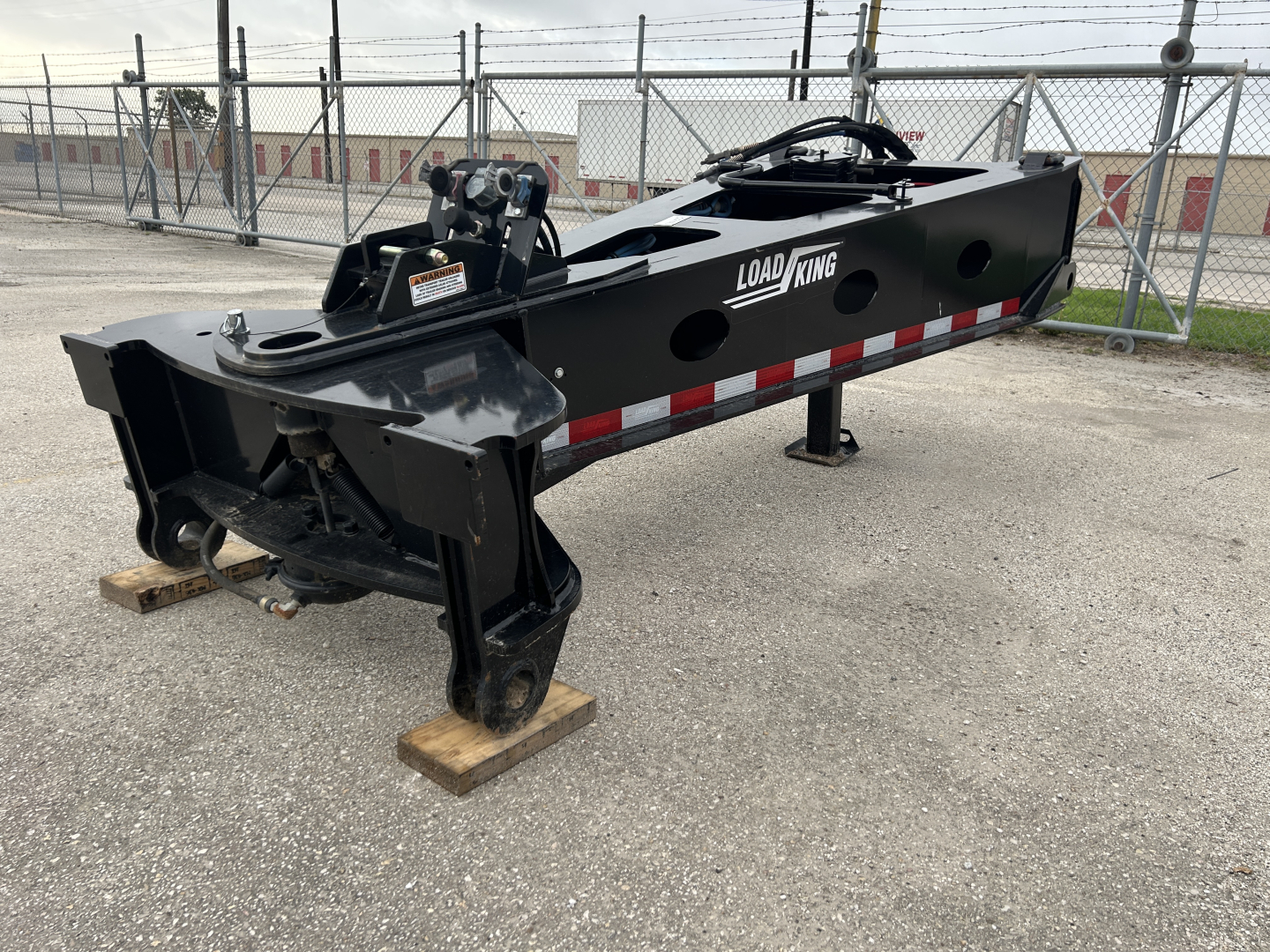 Load King trailer hitch assembly showing black metal frame with red/white reflective stripes and Load King logo.