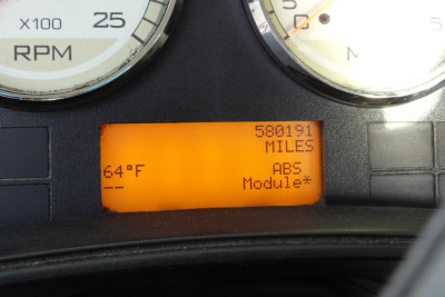 Instrument cluster with orange LCD showing 580,191 miles, ABS Module, and 64°F near the left; tachometer and speedometer gauges visible.