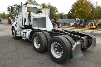 Truck chassis and cab of an International ProStar+ 113 conventional daycab showing rear dual axles and fifth wheel.