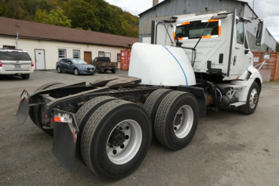 Truck rear view showing chassis and dual rear axles of a 2013 International PROSTAR+ 113 conventional daycab with white cab and exposed coupling area.