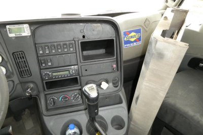 Cab interior of a 2013 International PROSTAR+ daycab showing dashboard controls, steering column, gear shifter, and Sunoco sticker.