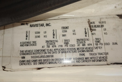 Plate on International PROSTAR showing GVWR and axle weights, tire sizes, and compliance text. Reads Navistar label with front/rear axle weights and capacities.