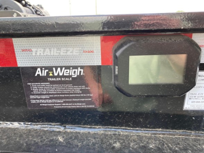Trailer center console with Air-Weigh trailer scale display and label, showing text ‘Trail-Eze’ and dashboard screen, rugged exterior and stickers.