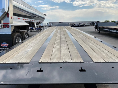 Trail-Eze TE1101 trailer flatbed deck showing wood planks and steel rub rail on the trailer bed.
