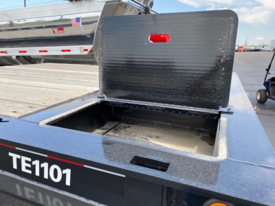 Trail-Eze TE1101 trailer toolbox lid open showing storage area and TE1101 label on side.