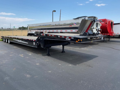 Trail-Eze TE1101 traveling axle trailer in side view showing polished steel dump bed and black chassis with decals TE1101