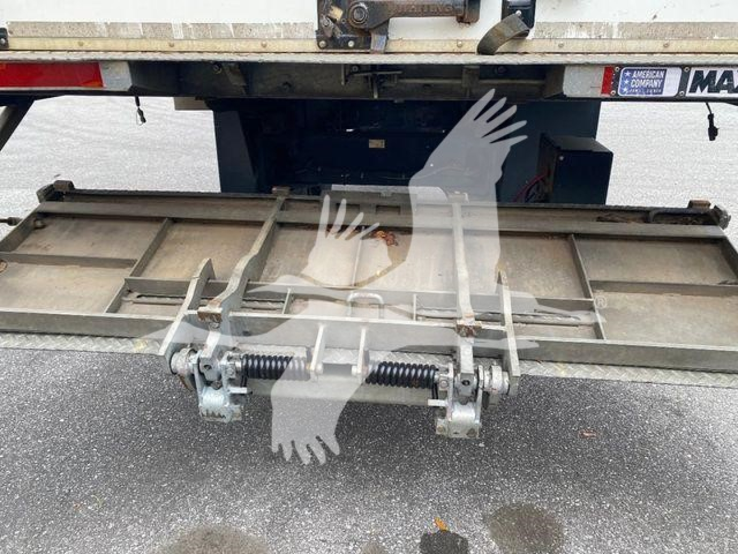Isuzu truck tailgate mechanism and platform platform undercarriage showing latch hardware and springs.