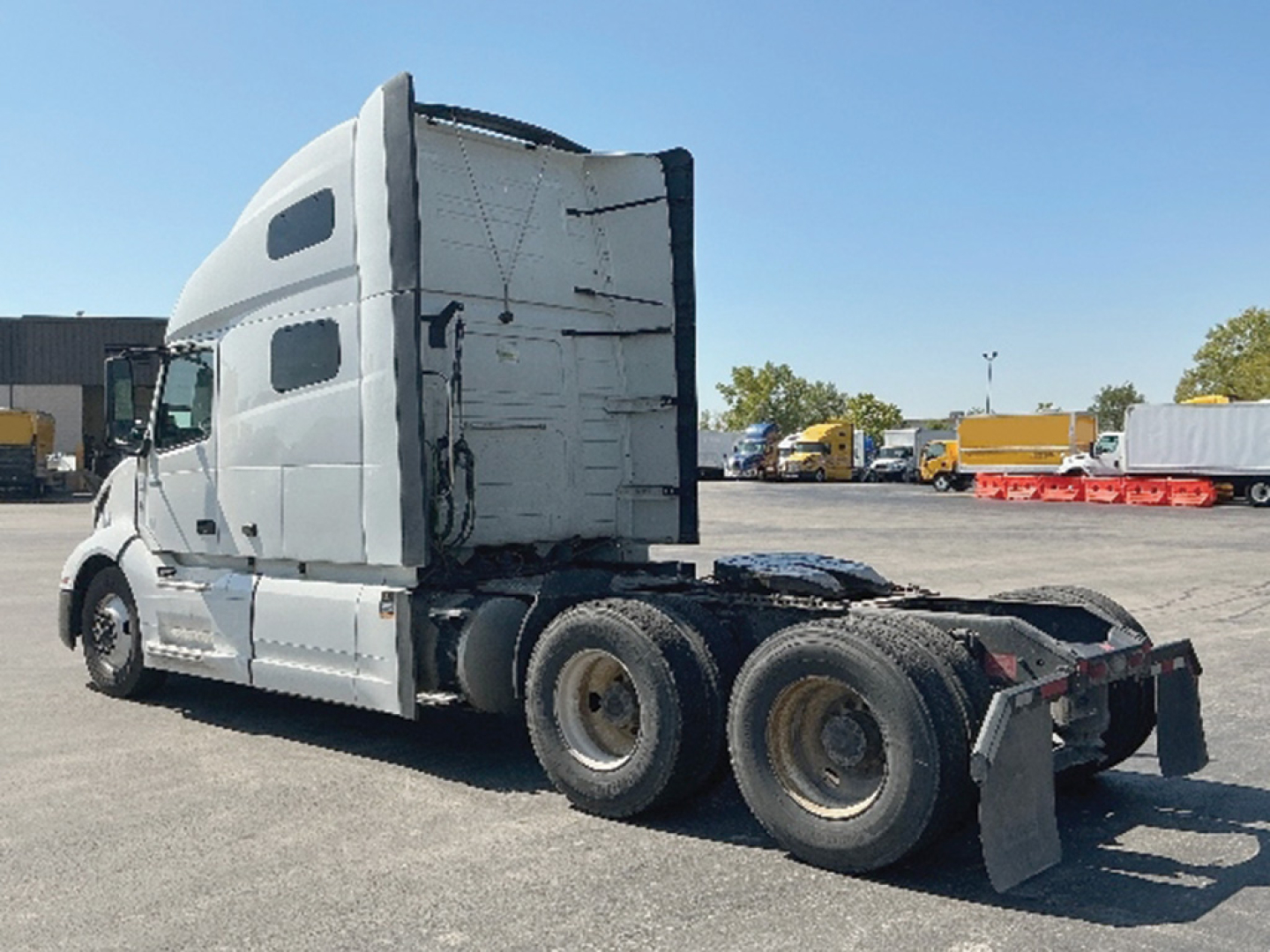 Volvo VNL 760 tractor rear view showing sleeper cab and dual rear axles in a trucking yard.