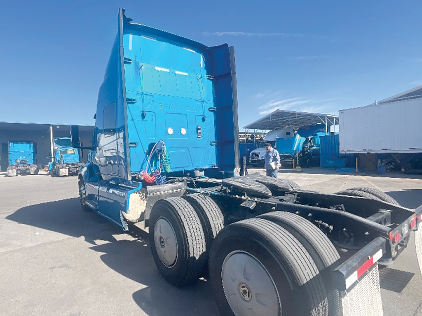 Truck cab and chassis showing International LT625 rear view with blue sleeper, dual rear axles, and fifth-wheel mount.