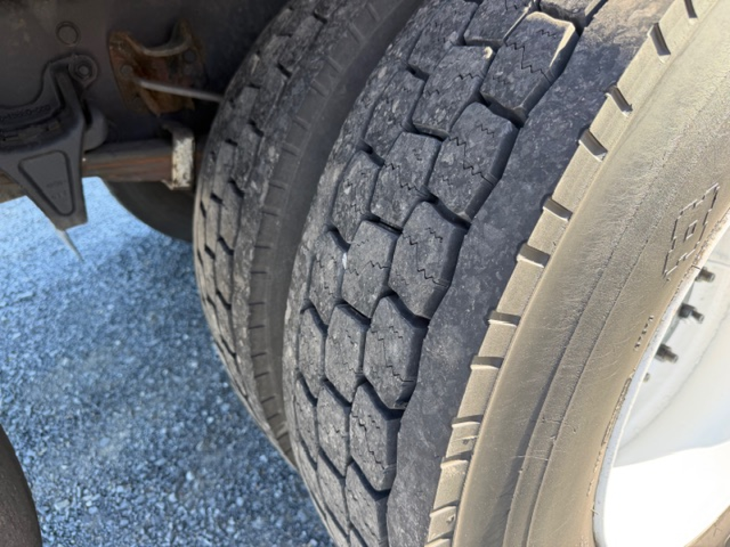 Rear wheel and dual-tire assembly of a Freightliner M2 106 truck showing tire tread and undercarriage components.