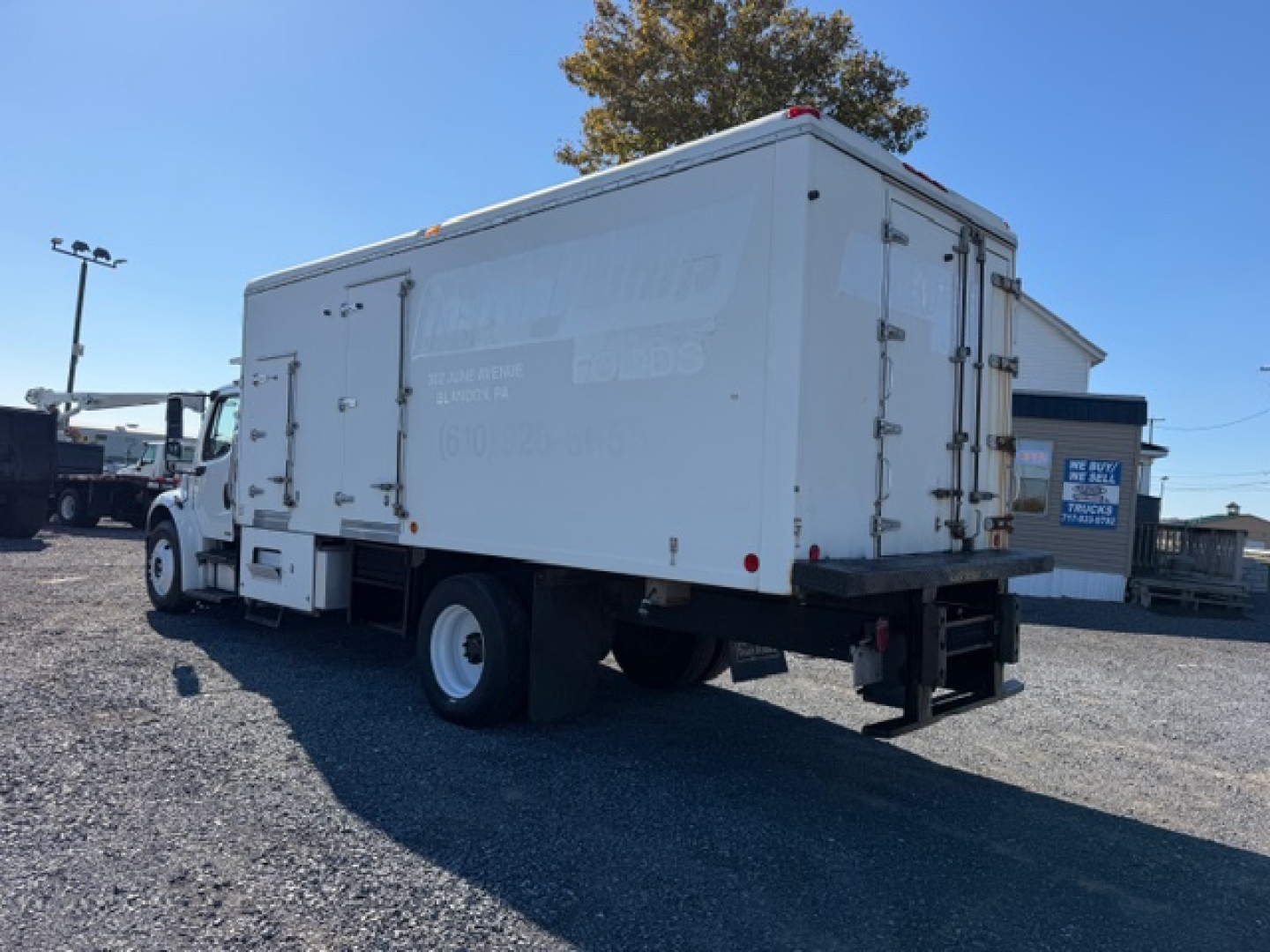 Freightliner M2 106 refrigerated truck rear-side view showing cargo box and wheels