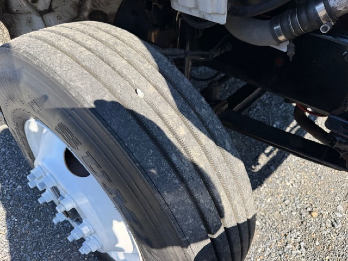 Freightliner M2 106 wheel hub and dual rear tires view showing tire treads and white wheel with lug bolts.