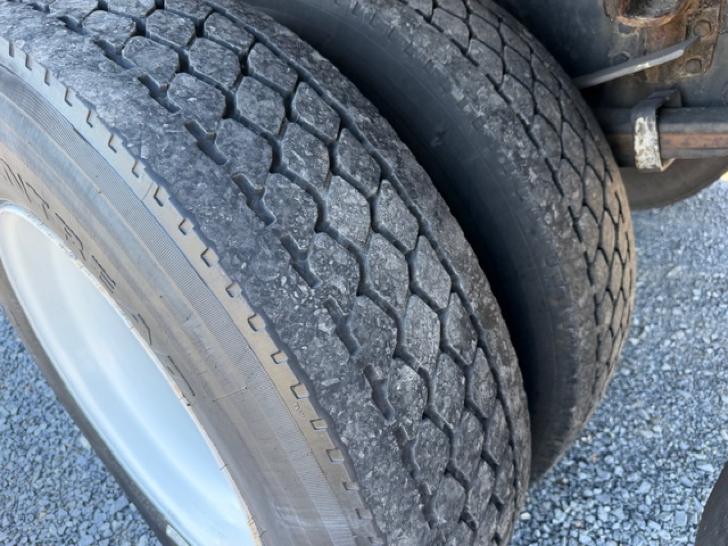 Truck wheel and dual tires on a Freightliner M2 106 refrigerated truck showing tread pattern and wheel rim.