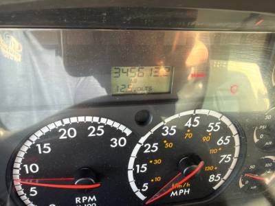 Dashboard of a Freightliner M2 106 showing RPM gauge and speedometer with digital readout visible; numbers and dials in view
