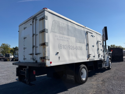 Freightliner M2 106 refrigerated truck side/rear view showing cargo van with faded markings and contact number on the box.