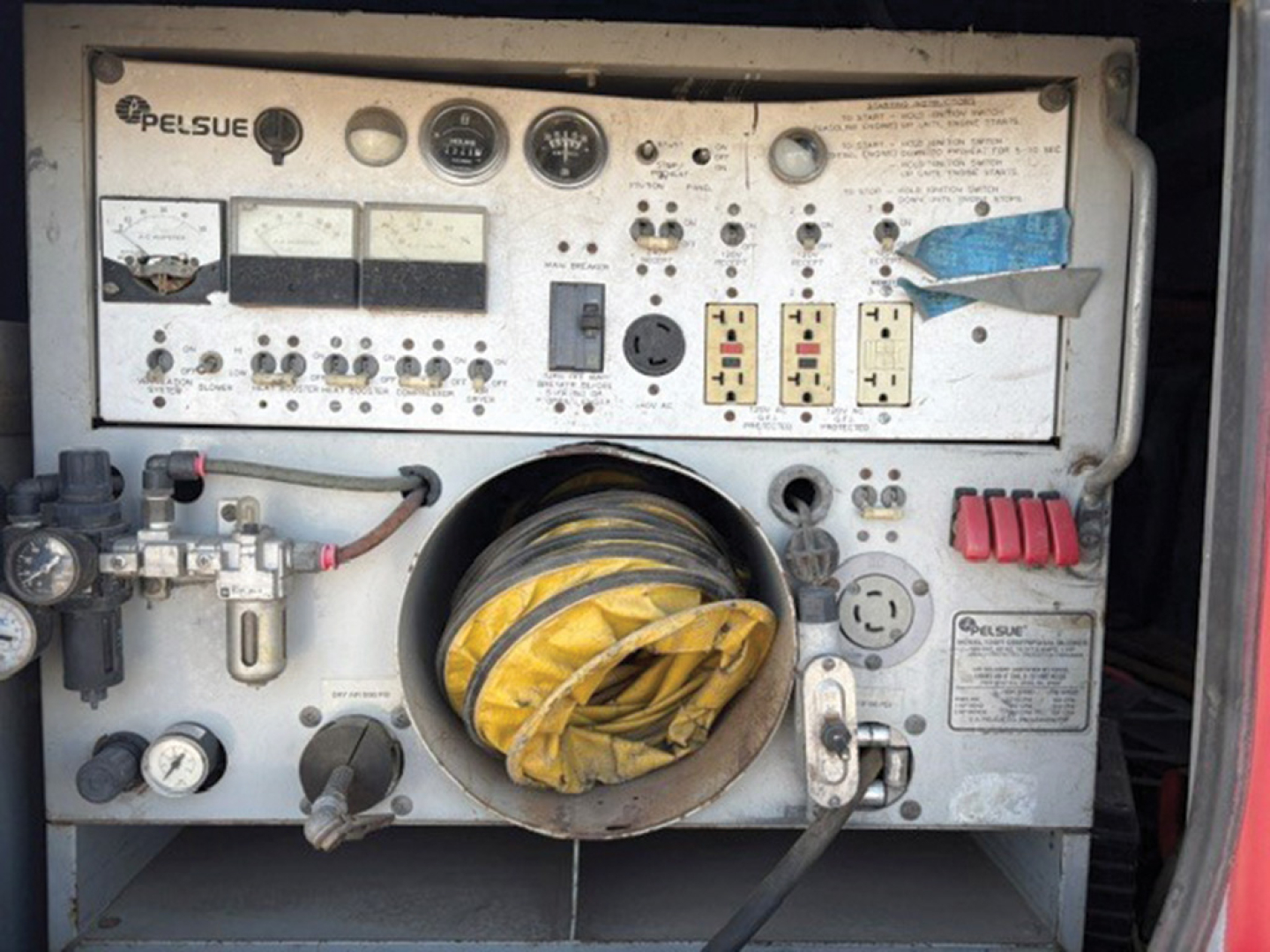 Control panel of a Lelsue generator with gauges, outlets, and yellow folded cable inlet visible inside a circular intake.