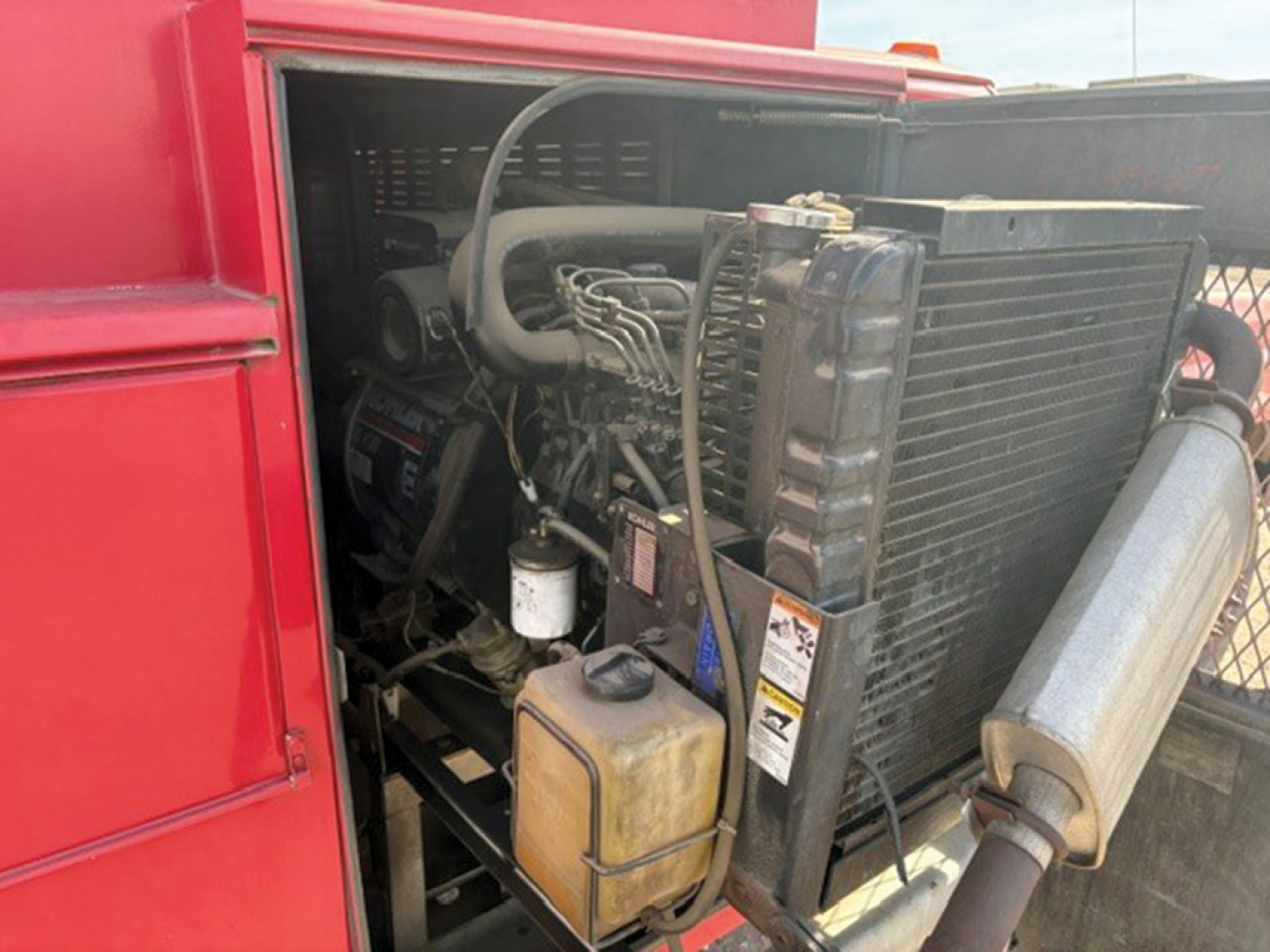 Ford F-350 Super Duty engine bay showing radiator, coolant reservoir, and hoses in a service truck bed.