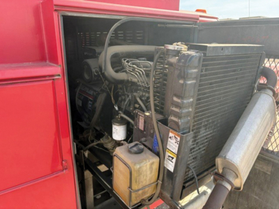 Ford F-350 Super Duty engine bay showing radiator, coolant reservoir, and hoses in a service truck bed.