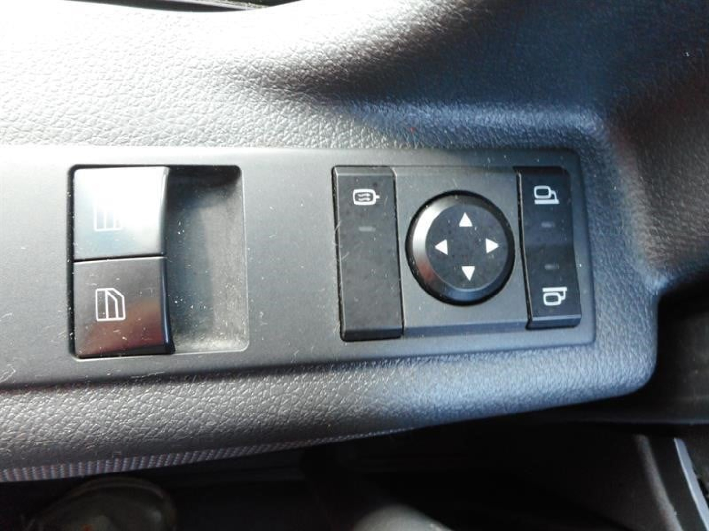 Cab controls panel with window/mirror switch cluster visible; circular directional pad and other switch symbols.
