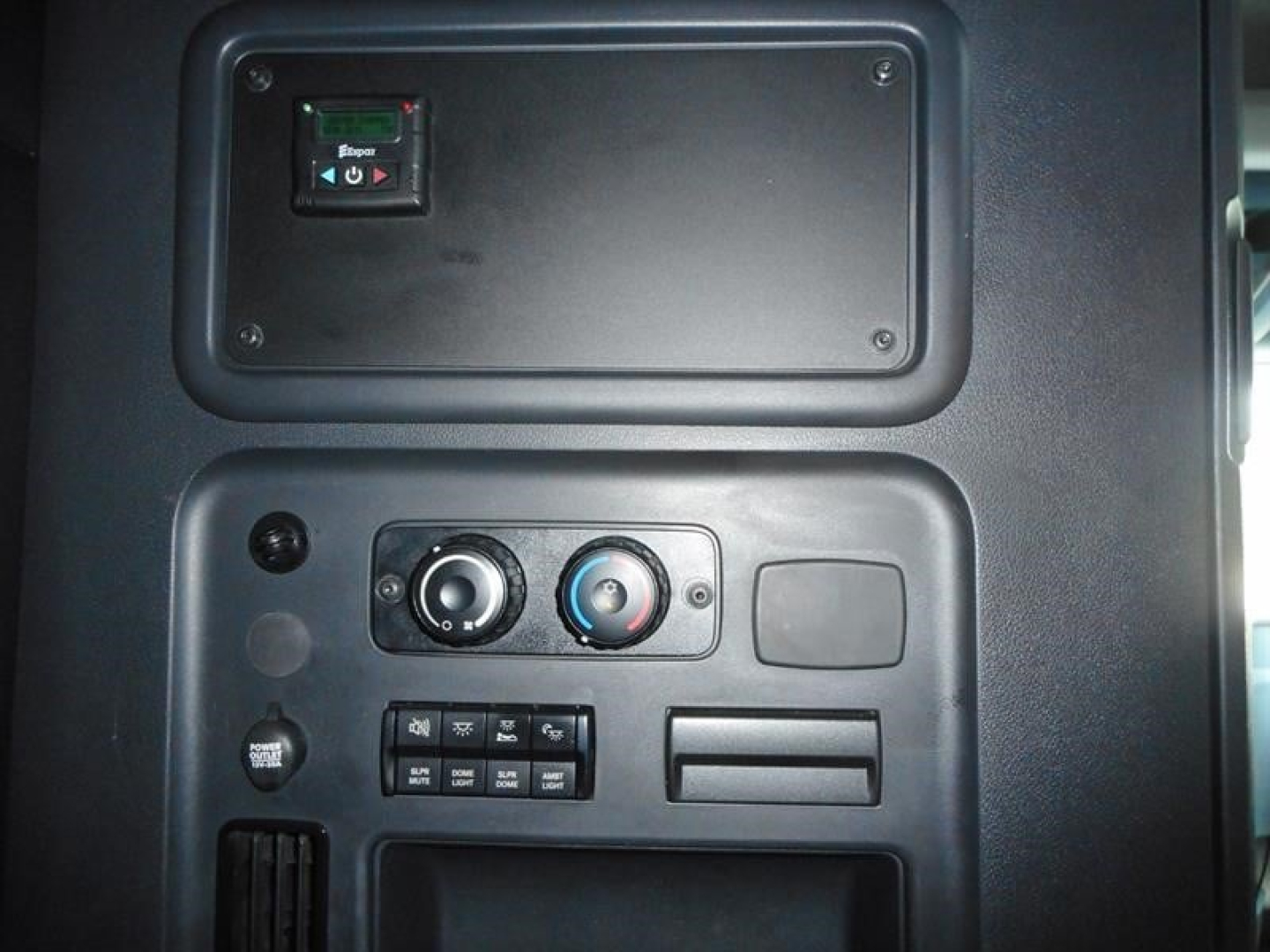 Cab interior of a Freightliner Cascadia 126 showing control panel with toggles, climate knobs, and storage compartments.