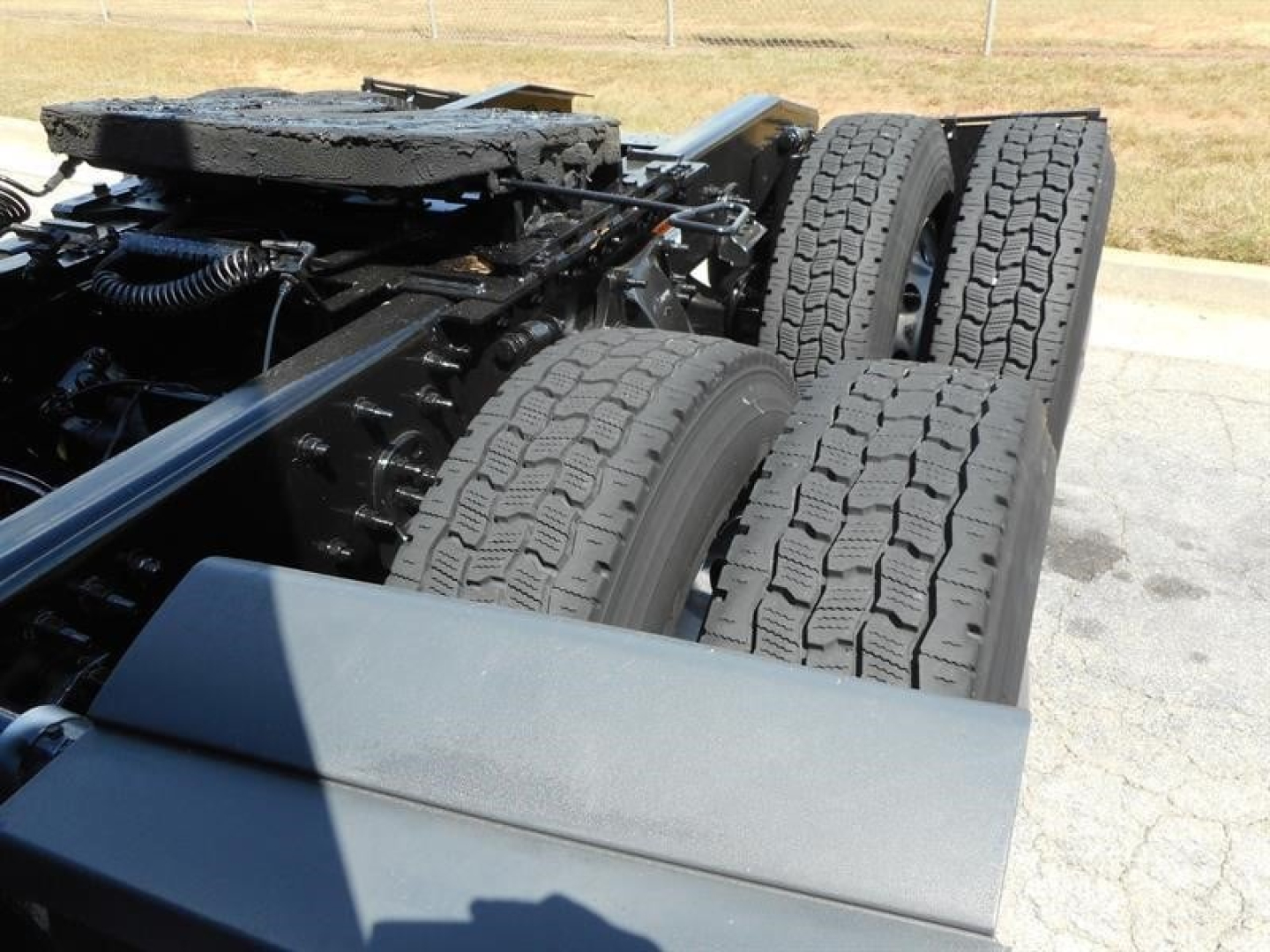 Truck chassis showing dual rear axles and tires with heavy tread, part of Freightliner Cascadia 126 undercarriage.