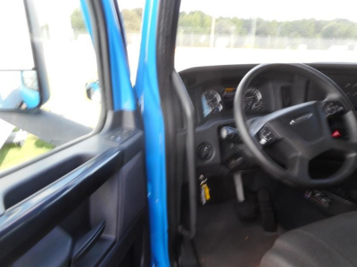 Freightliner Cascadia truck interior view showing steering wheel and instrument cluster from the driver’s door area.