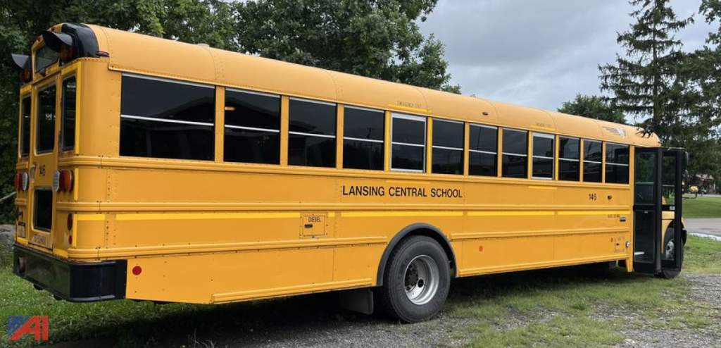 Yellow Thomas CE series school bus side view showing Lansing Central School text and black-tinted windows.