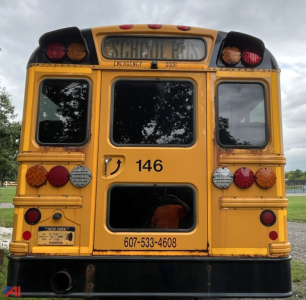 Rear view of a 2018 Thomas CE Series school bus showing the back doors, emergency exit, and contact number with bus ID 146.
