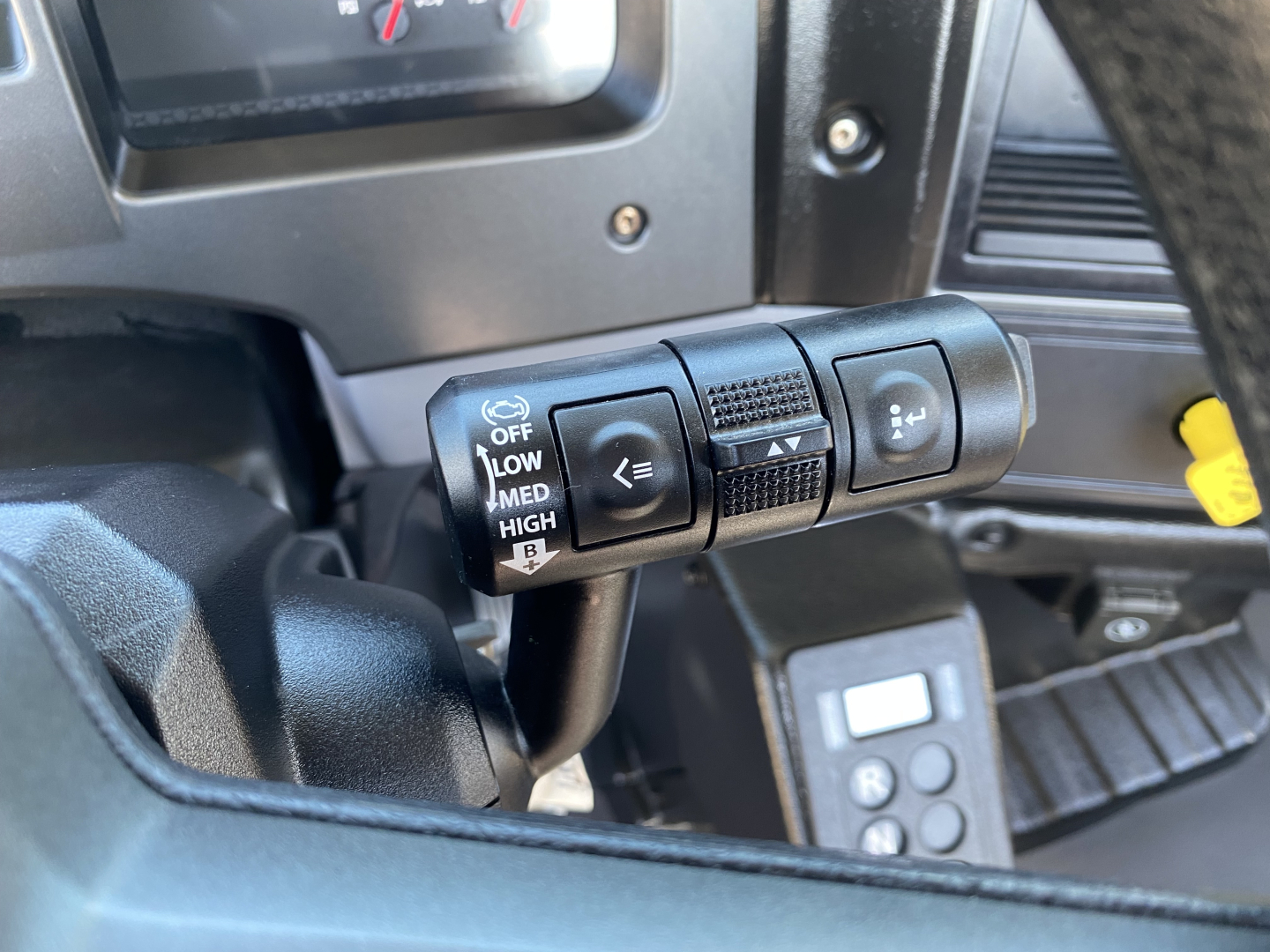 Dashboard stalks and controls in a 2024 Mack MD6 E truck showing cruise control and turn signal stalks with center wheel and dashboard in view
