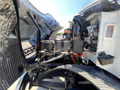 Mack MD6 E truck interior cab area showing dashboard switches, steering column, wiring, and open hood with exposed engine components.