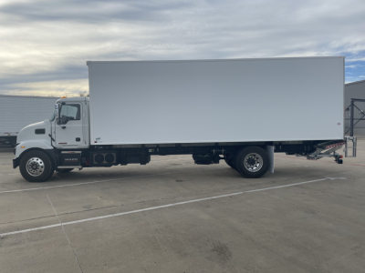 Mack MD6 E box truck side view showing white cargo box and cab with HINO-style grille? (Note: image shows a white dual-axle truck with large rectangular cargo box; no legible text visible on vehicle)