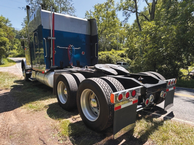 Peterbilt 379 UltraCab extended hood tractor rear view showing dual rear axles and mud flaps.