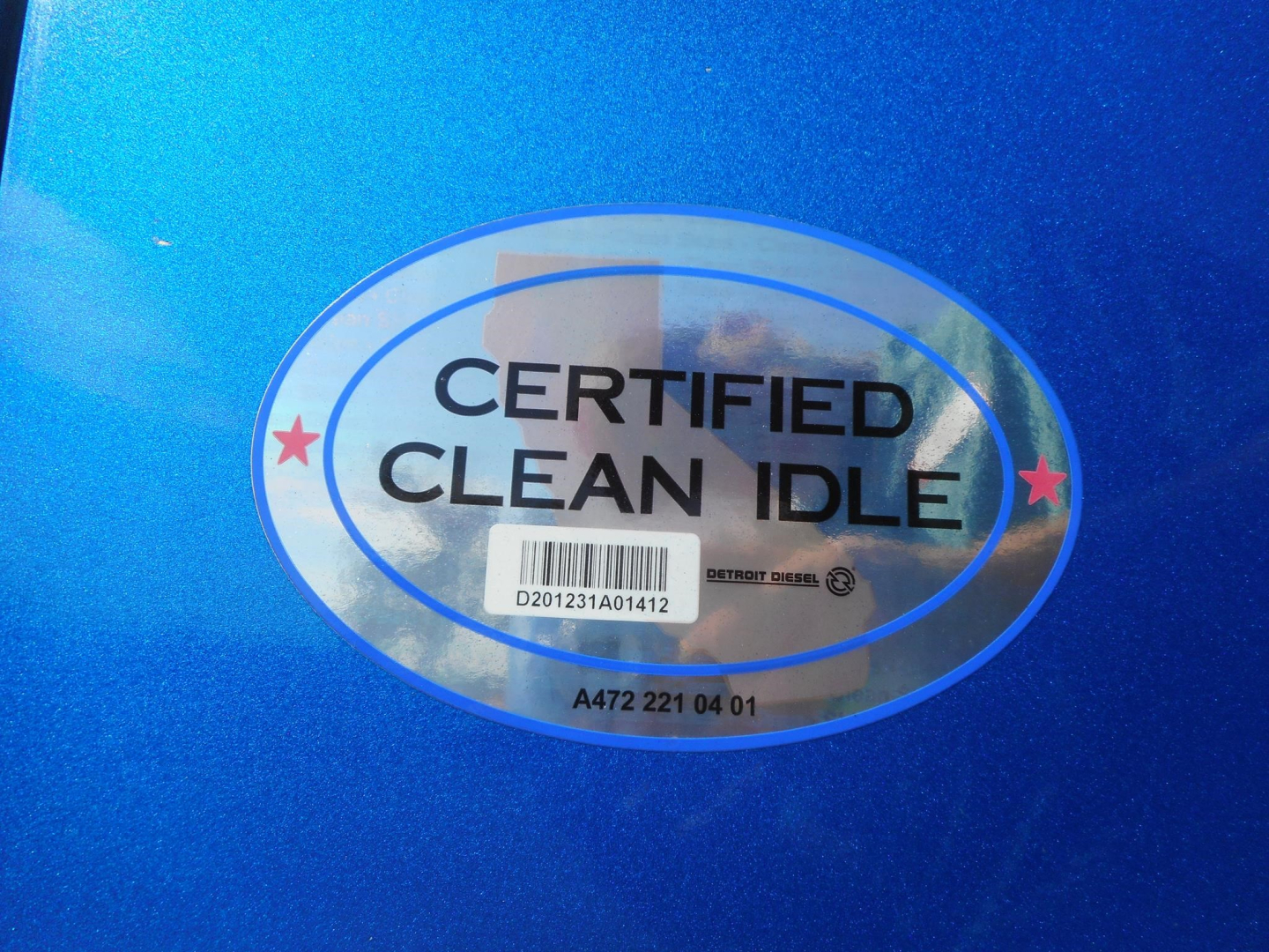 Sticker on blue truck shows 'Certified Clean Idle' with barcode and Detroit Diesel logo.
