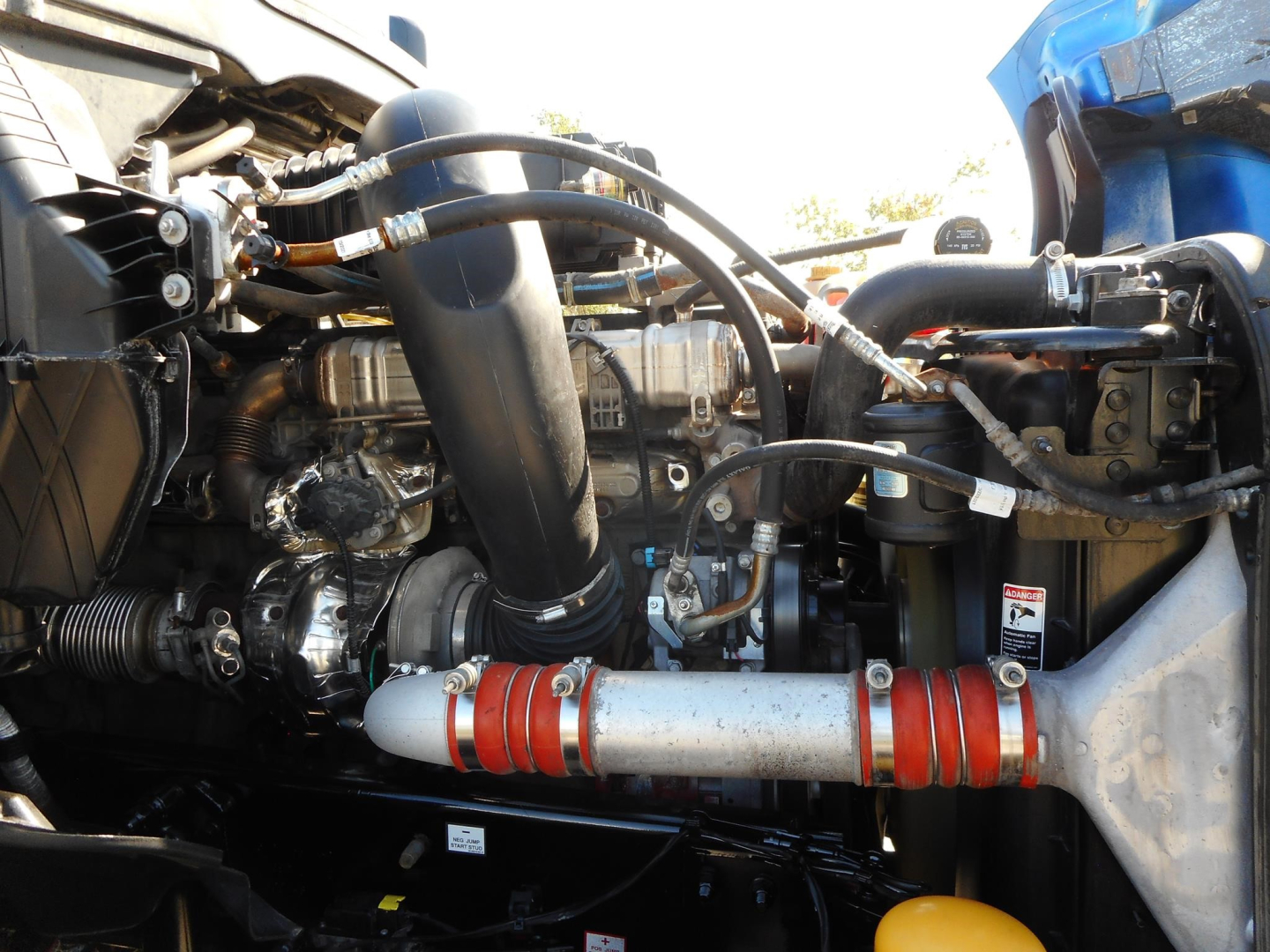 Freightliner Cascadia 126 engine bay showing hoses, intercooler piping, and exhaust aftertreatment with red silicone couplers