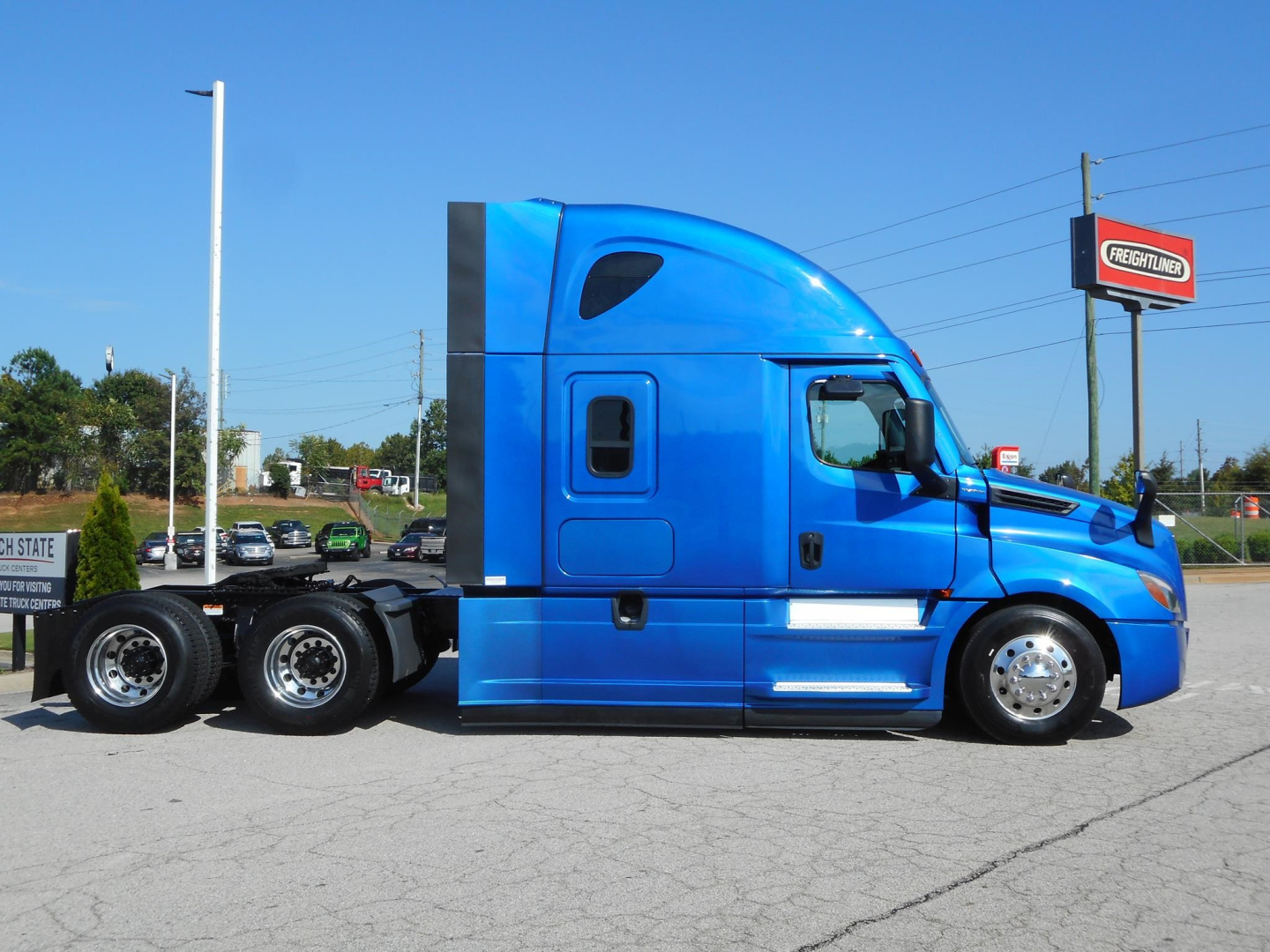 Freightliner Cascadia 126 semi-truck side view showing blue paint and sleeper cab.