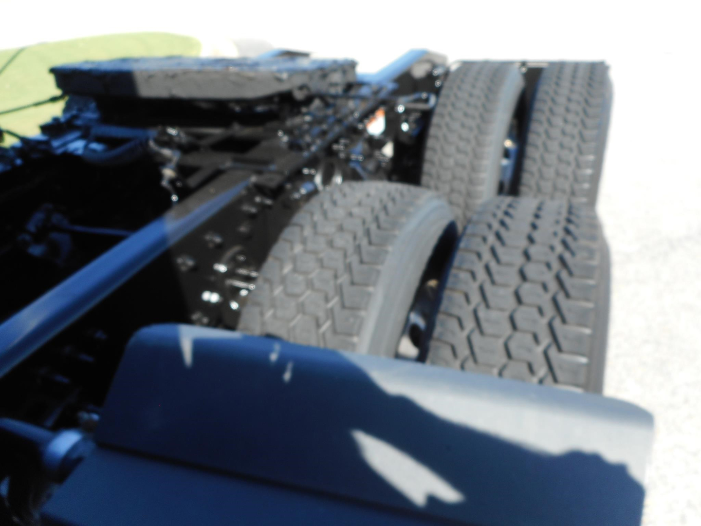 Freightliner Cascadia truck chassis and dual rear tires visible from side view.