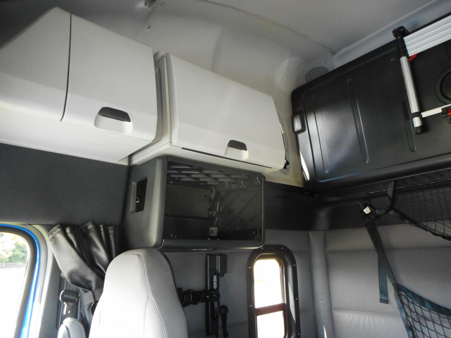 Freightliner Cascadia truck cab interior showing overhead compartments and storage shelves.