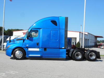Blue Freightliner Cascadia 126 day cab tractor in profile view showing cab and rear axles