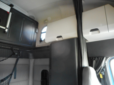 Cab interior of a 2022 Freightliner Cascadia 126 with overhead sleeper cabinets and control panels visible.
