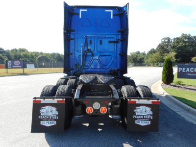 Rear view of a blue Freightliner Cascadia 126 tractor chassis showing fifth wheel, dual rear axles, and mud flaps with Peach State Trucking branding.